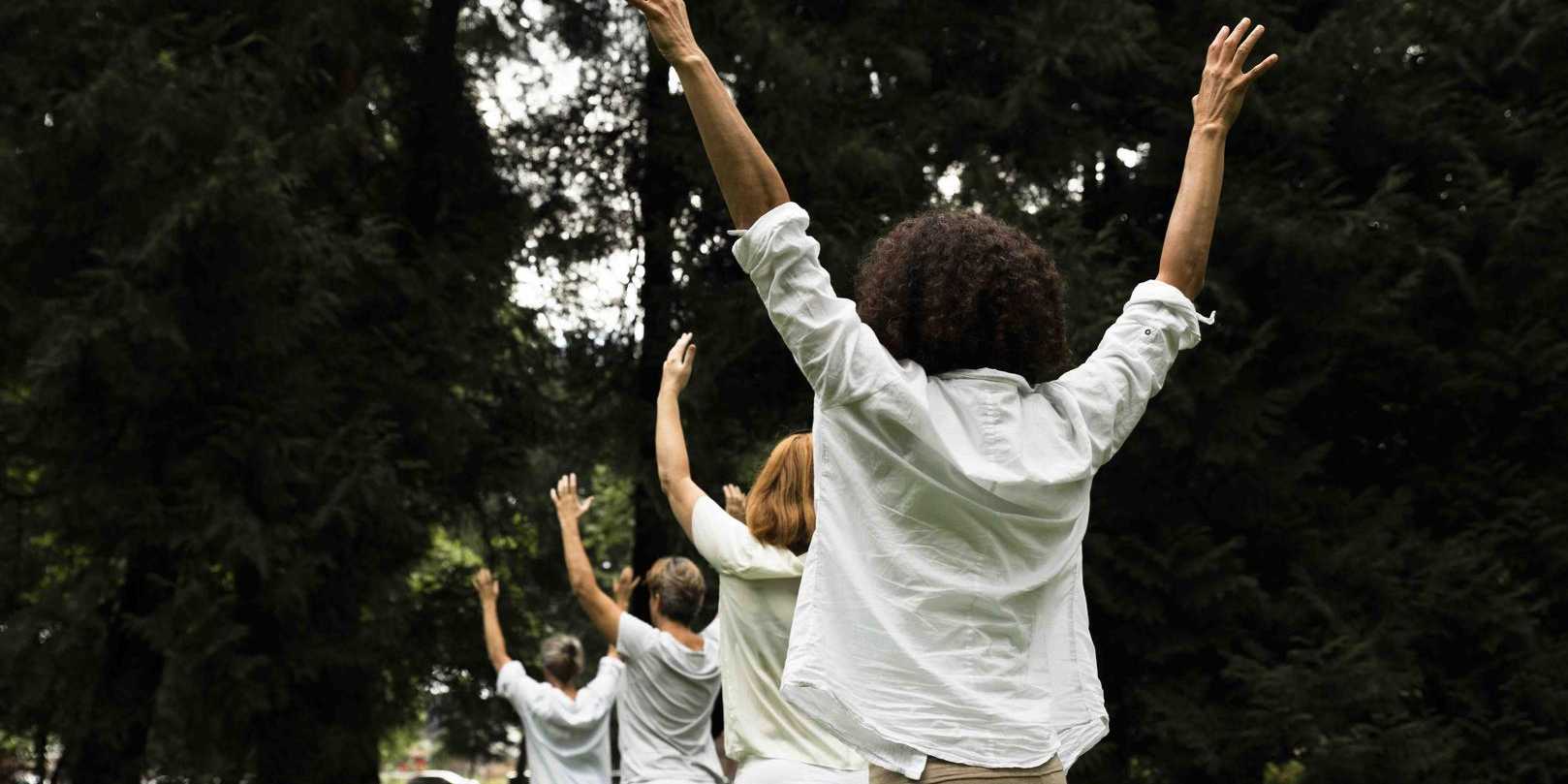 Mensen buiten lopend achter elkaar door natuur.