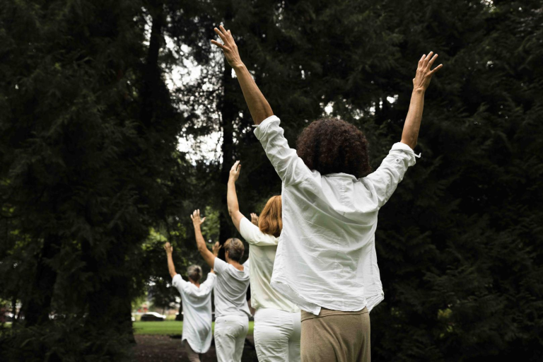 Mensen buiten lopend achter elkaar door natuur.